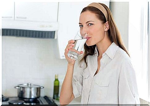 A woman drinking a glass of water. 