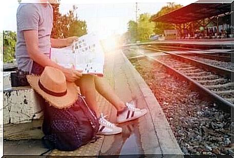 A man waiting for the train on the station platform. 