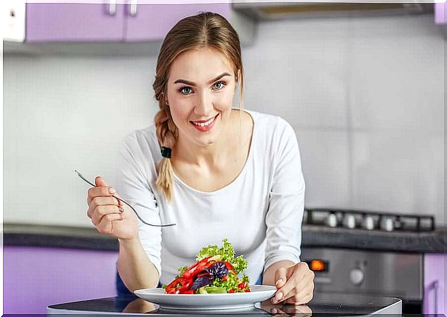 A woman eating a salad.