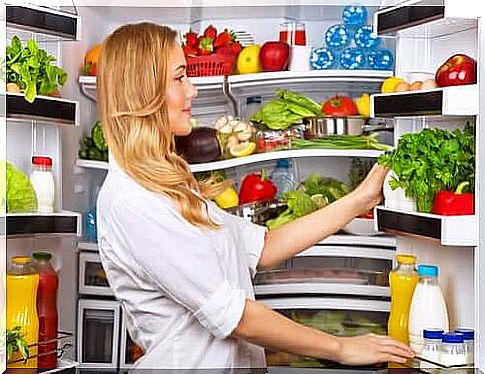 A woman in front of her refrigerator.